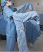 putting on surgical gown